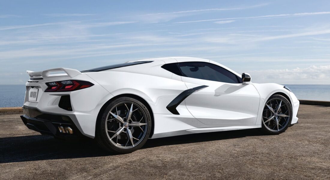 Corvette C8 Stingray - Seitenansicht Weiße Chevrolet Corvette C8 Stingray in Seitenansicht am Meer geparkt