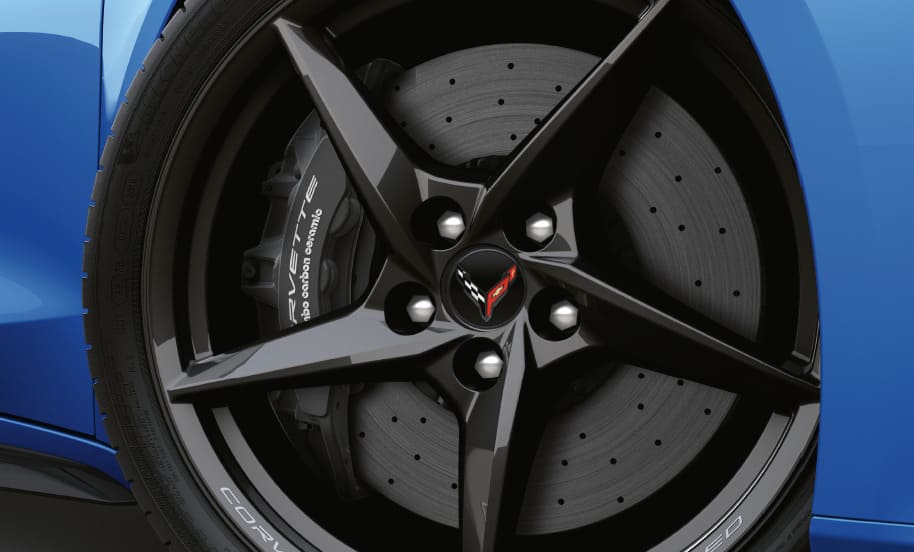 Nahaufnahme eines schwarzen Leichtmetallrads der Chevrolet Corvette E-Ray mit Bremsscheibe und Bremssattel.